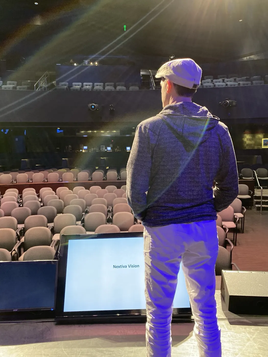 Matthew Dearing at center stage in a large venue, facing the seats before a keynote.
